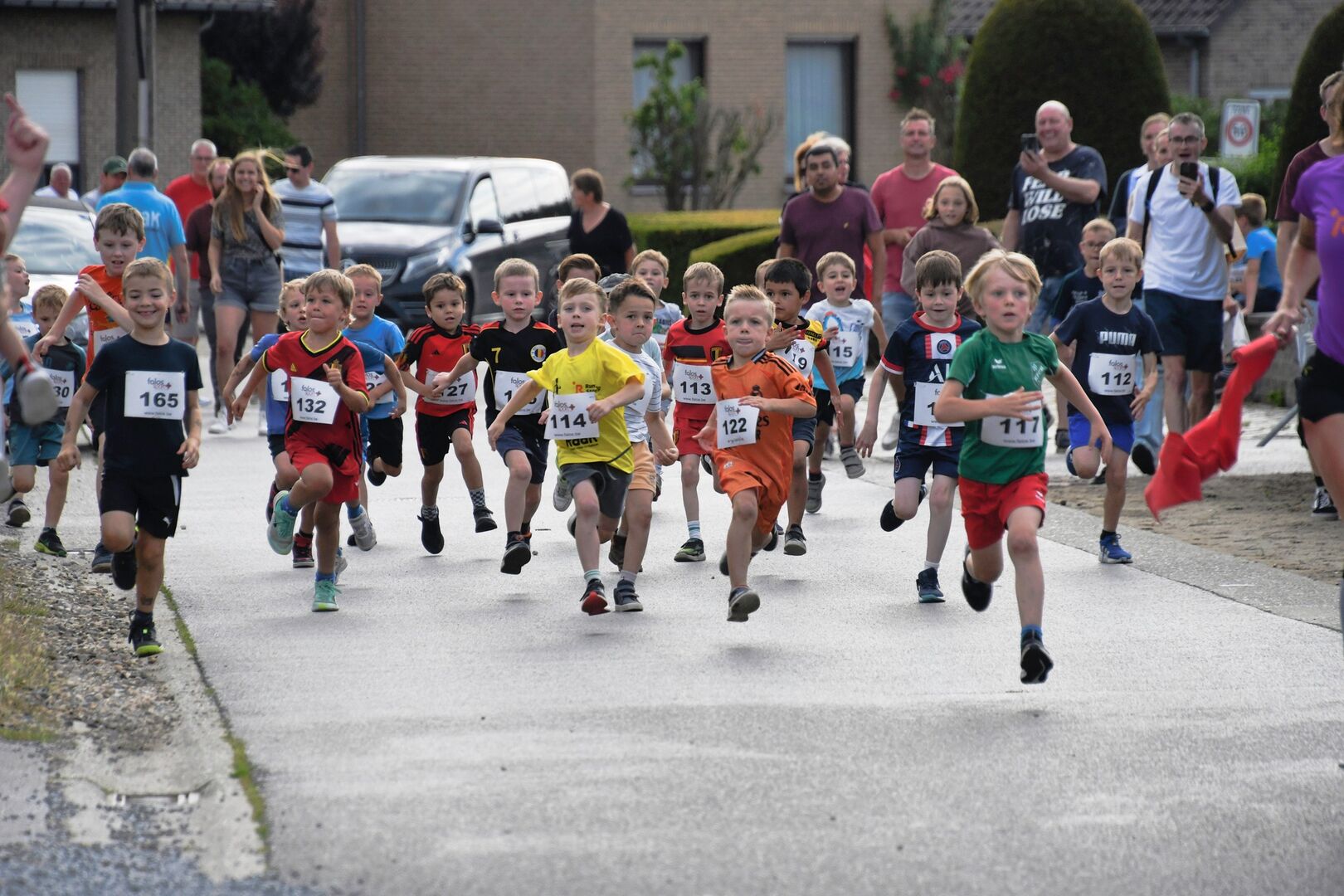 Kinderen lopen door Hallaar met supporters